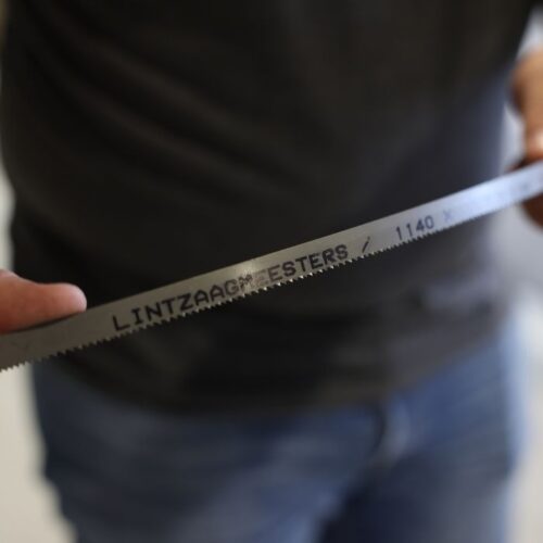 Detail van een Lintzaagmeesters lintzaagblad met fijne vertanding en opgedrukte maataanduiding